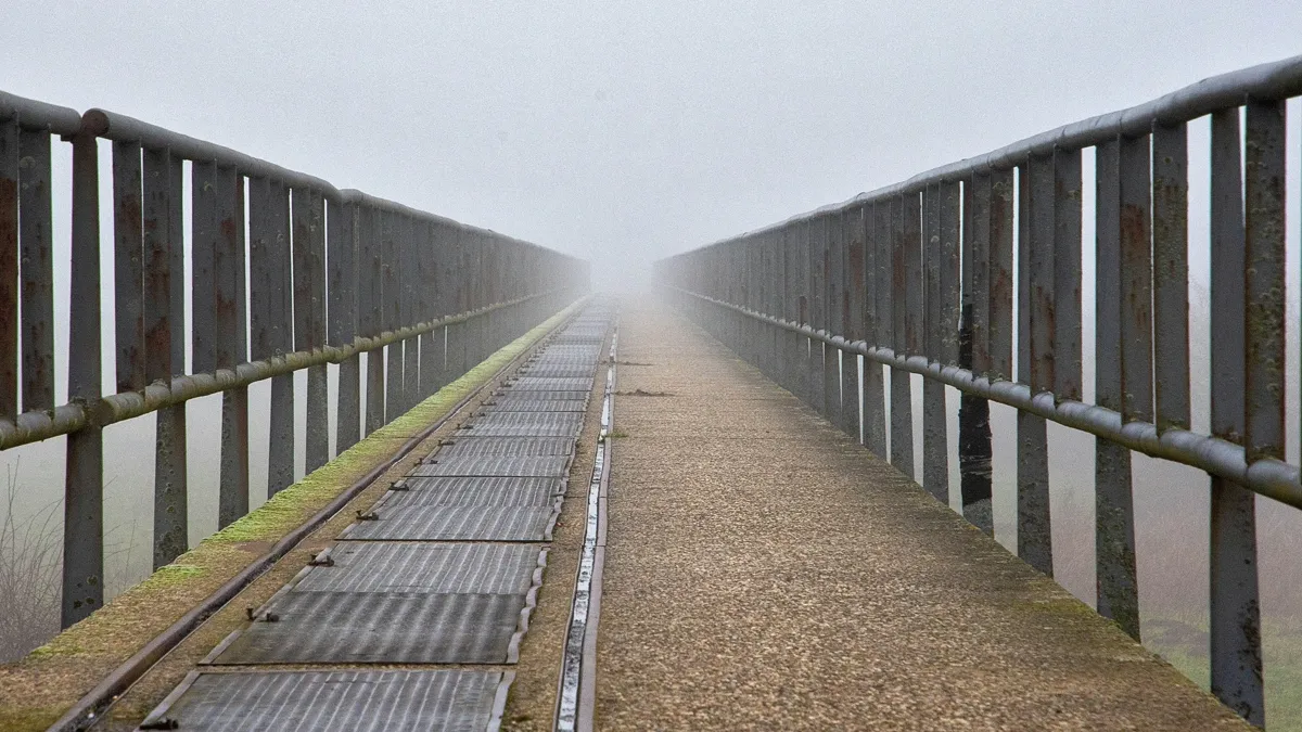 霧の中の鉄柵のある橋